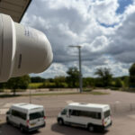 Hikvision CCTV camera installed overlooking a large outdoor area at a school site.