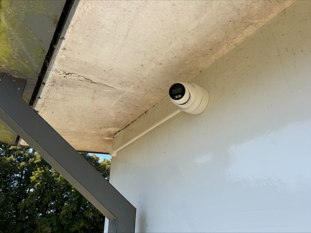 New Hikvision turret CCTV camera installed beneath an external overhang at a school building.